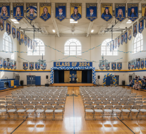 A colorful senior banner displayed at a high school graduation ceremony showcasing student portraits and class year.