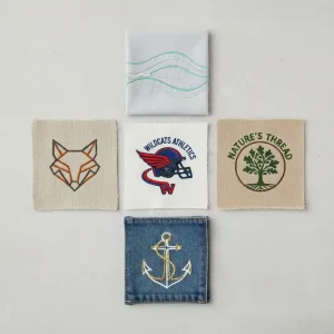 Different fabric types suitable for embroidery including cotton, linen, denim, canvas, and polyester blends displayed with embroidered samples